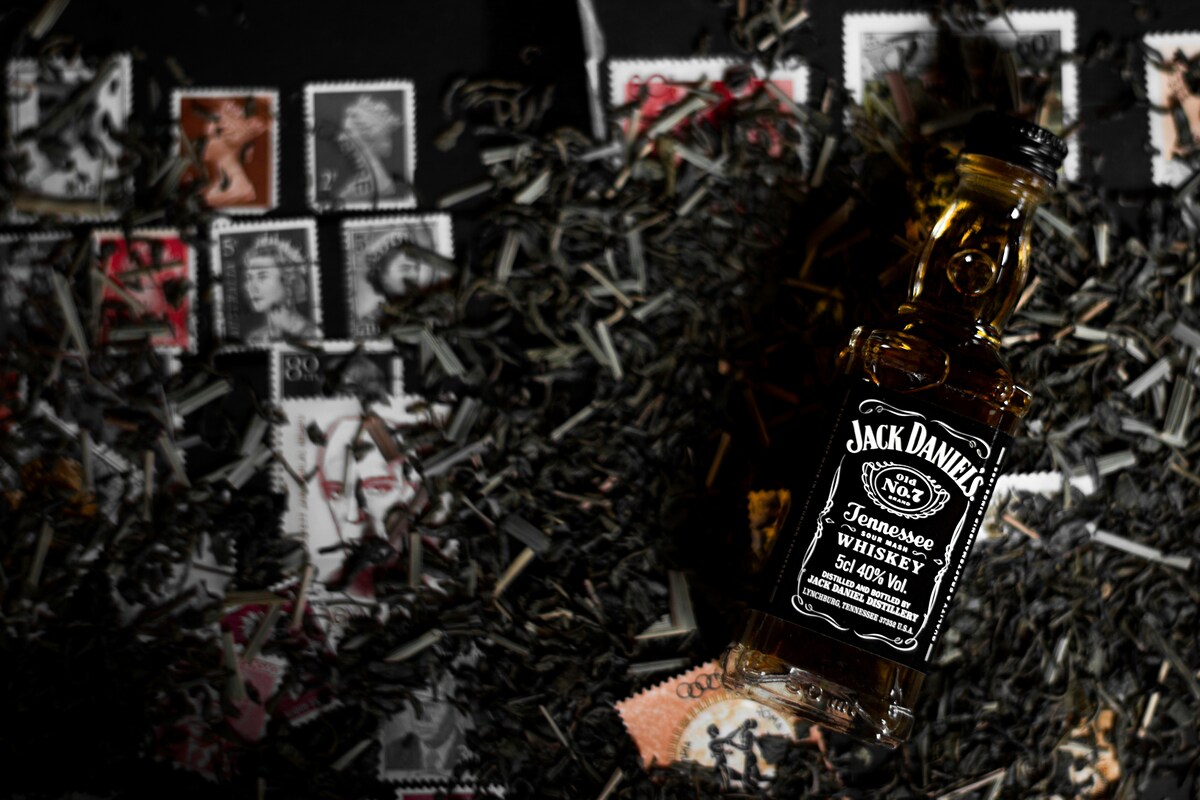 butelka jack daniel’s obok kolekcji znaczków pocztowych