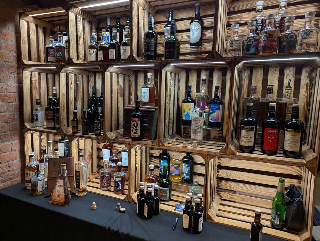 Rum explorer – zdjęcie z wydarzenia, prezentujące stoisko z rumami na zdjęciu widoczne jest stoisko rum explorer, z różnymi butelkami rumu ustawionymi na stole podczas whisky day cracow 2025